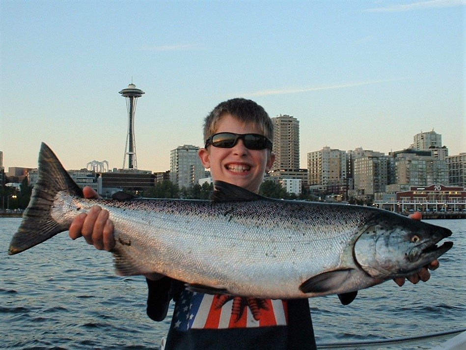Seattle salmon fishing salmon held by boy in front of Seattle waterfront
